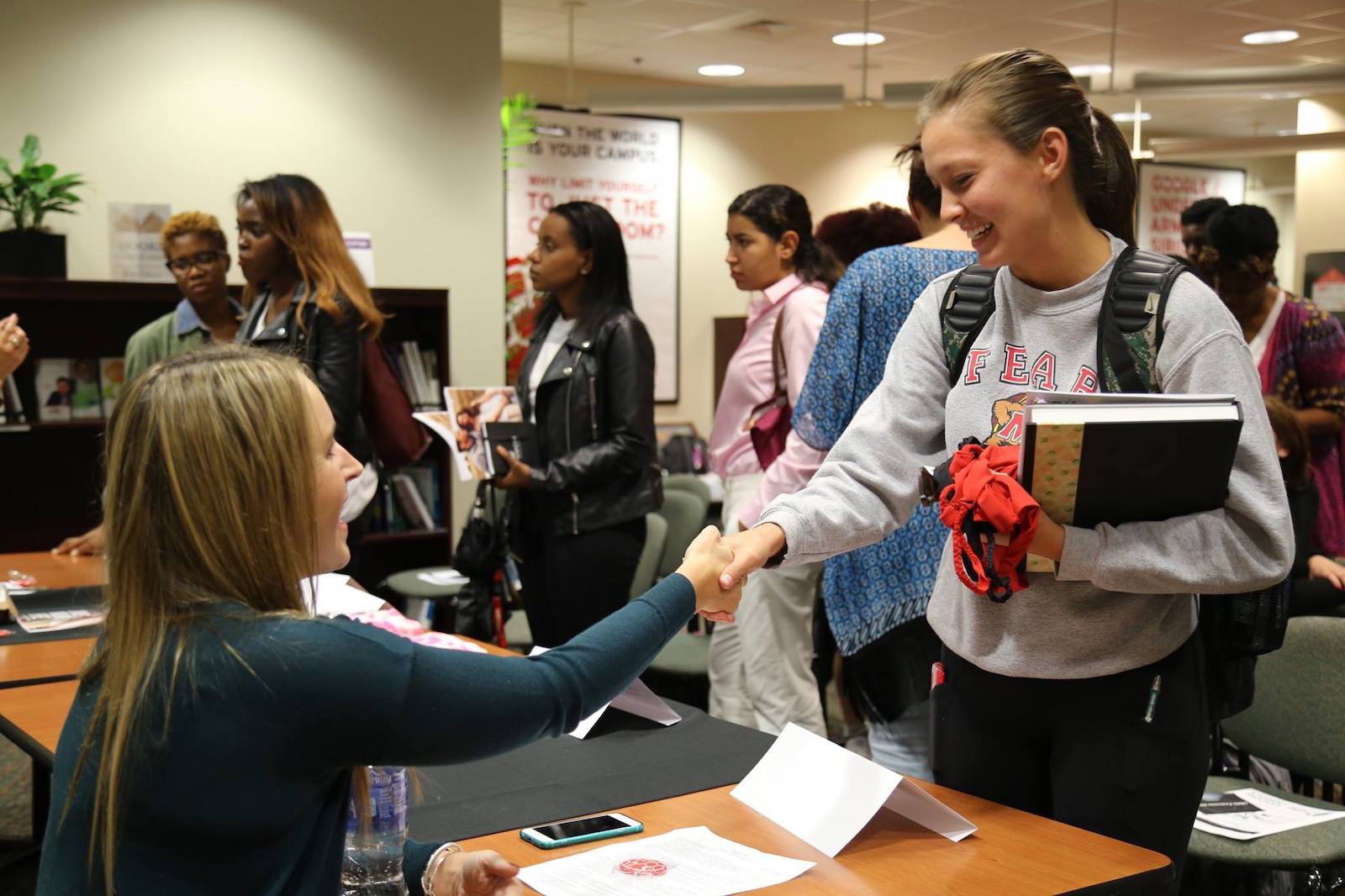 2 women shake hands at a career fair