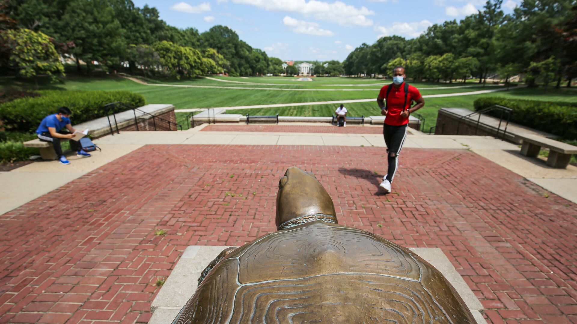 students walking in front of testudo statue