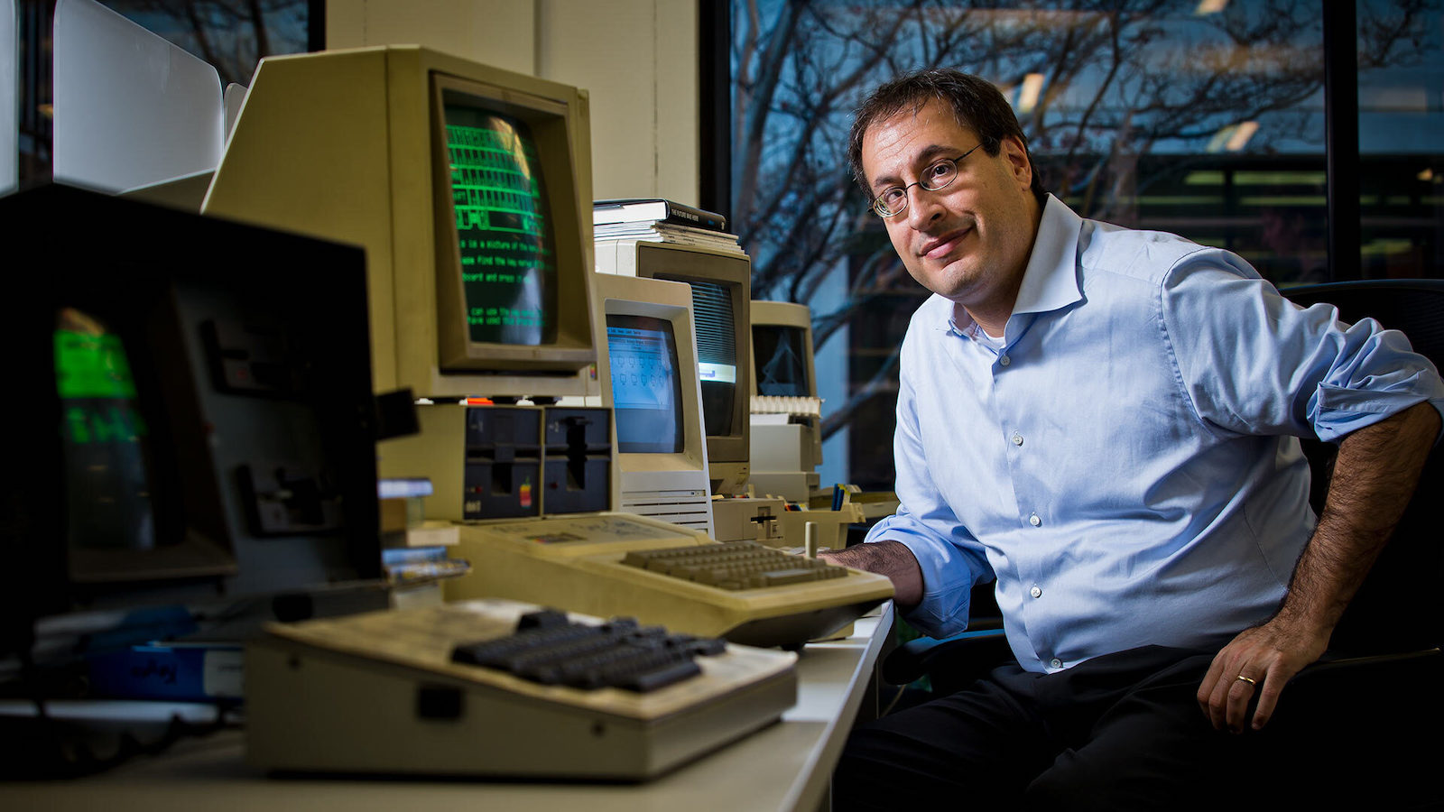 Matthew Kirschenbaum, a professor of English and digital studies at the University of Maryland, poses with some of the vintage PCs and word processing machines he uses to access old computer file formats. 