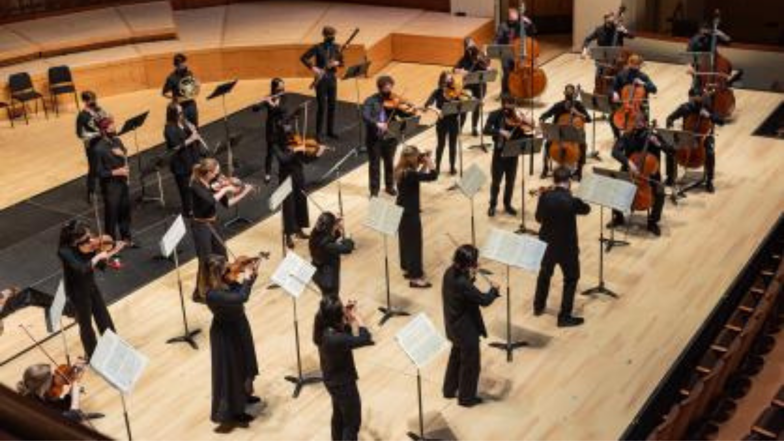 Students playing orchestral instruments on stage