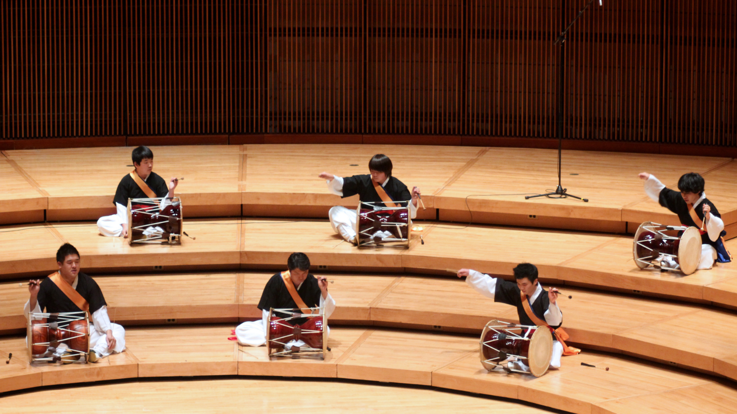 Members of the Korean Percussion Ensemble perform on stage. 