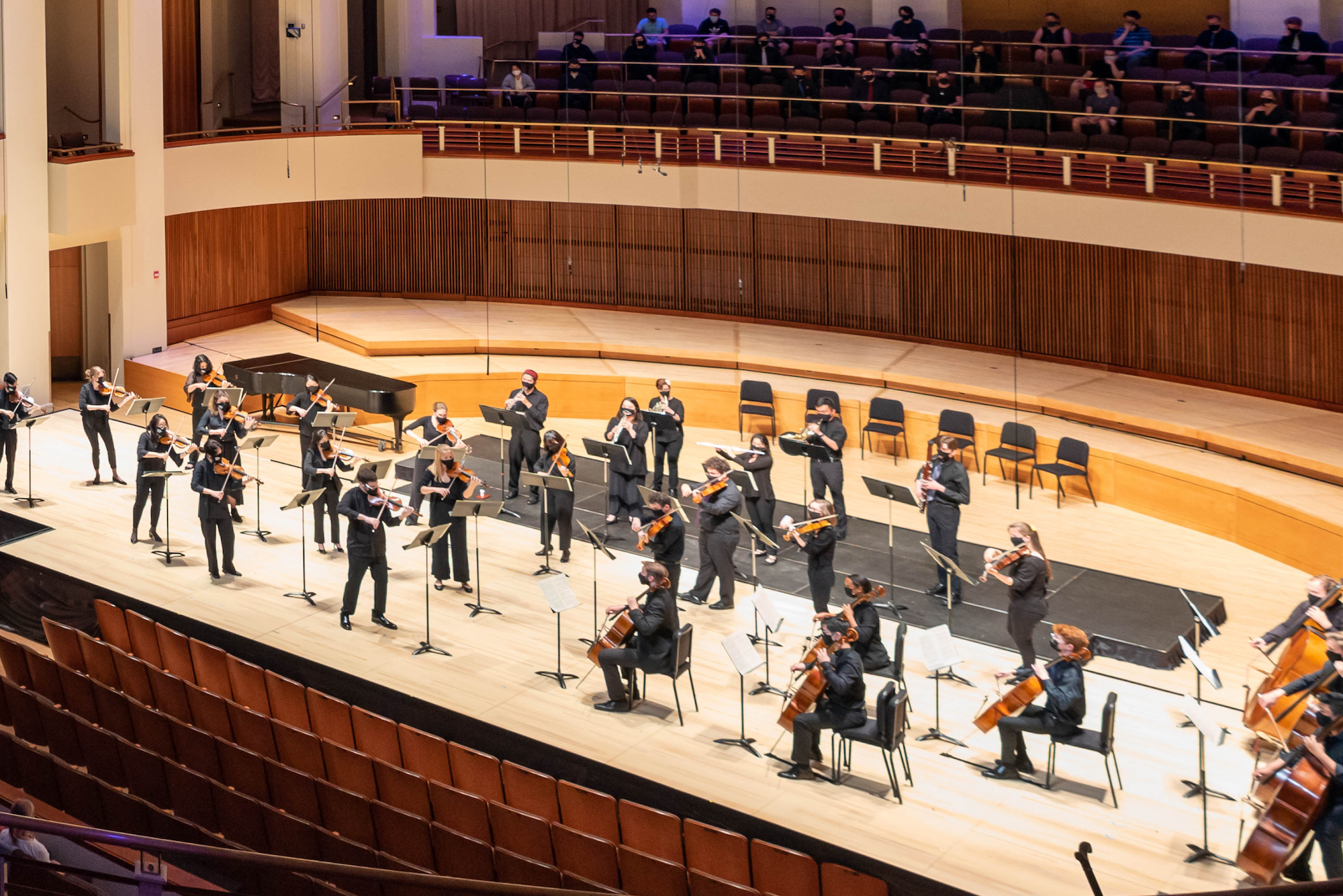 An orchestra performs on stage.