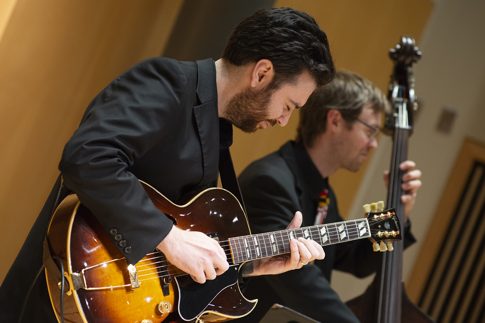 A man plays a guitar during a concert. 