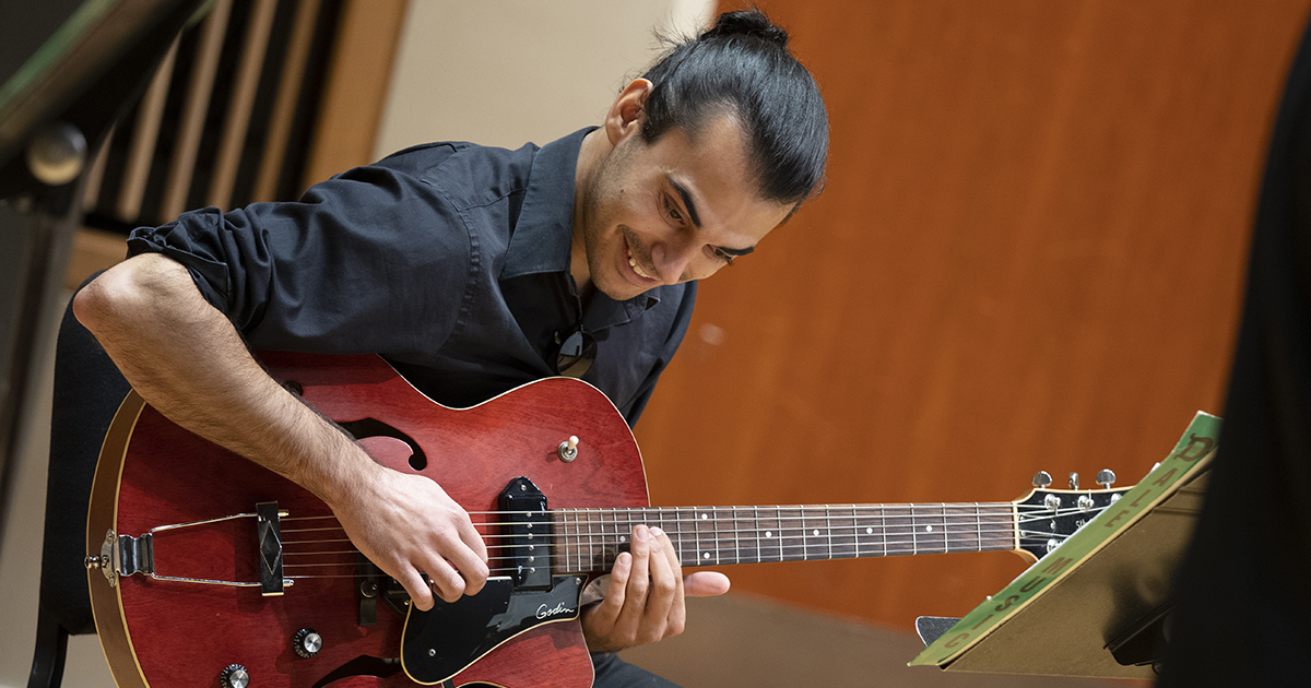 A man plays a guitar.