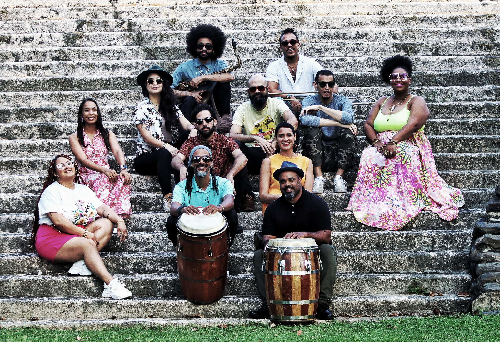 The 12 members of the ensemble El Laberinto del Coco pose on steps for a photograph.