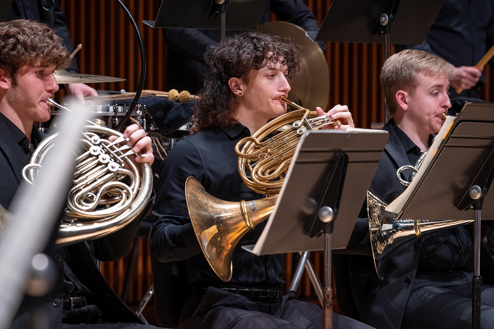 Members of the UMD Wind Orchestra play instruments during a concert.