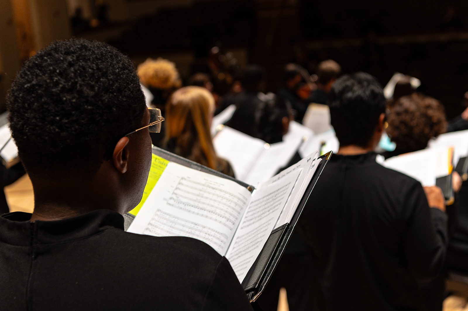 Choral student sings from sheet music during a concert.