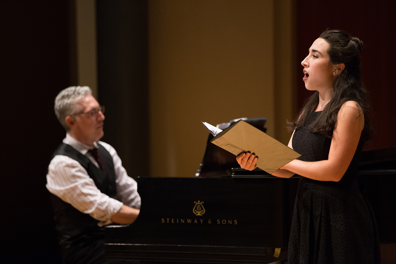 A student sings during a performance.