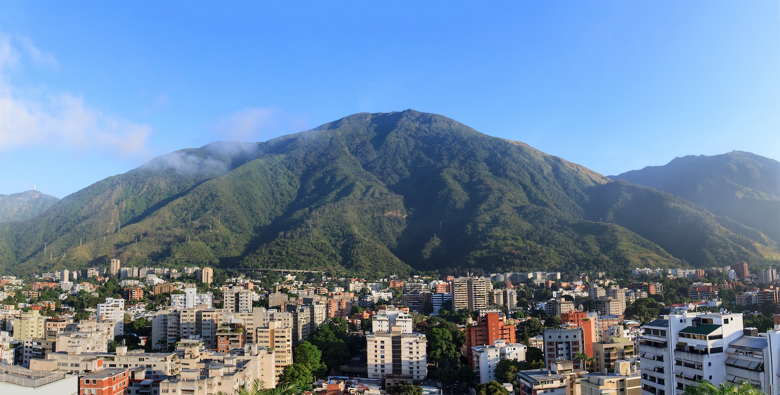 Image of a mountain in the background and buildings in the foreground.
