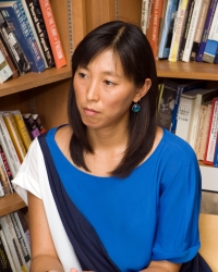 Photo of Naomi Paik in front of bookshelves