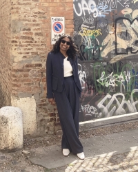 Smiling woman leaning against a brick wall