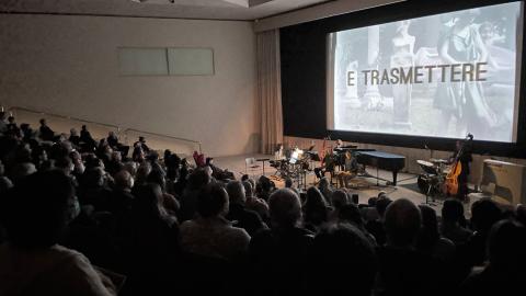 An audience watches a film with live accompaniment. 