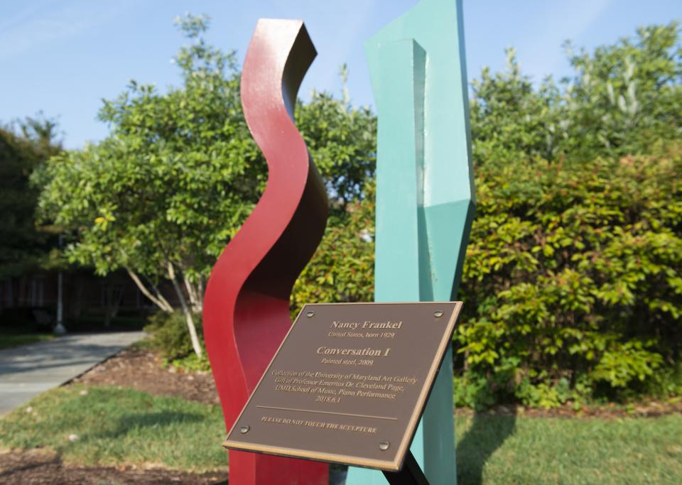  Red and green outdoor sculpture titled "Conversation I" by artist Nancy Frankel and plaque.