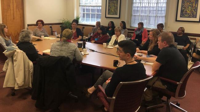 Staff in UMD's College of Arts and Humanities sit around a conference table in discussion