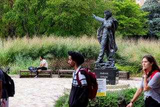 Students walk past the Frederick Douglass Statue on UMD's campus.