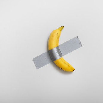 A banana duct-taped to a white wall
