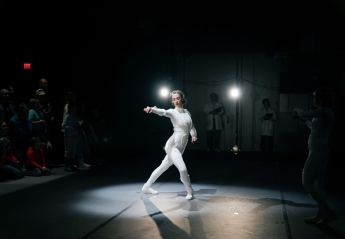 A dancer in a suit with robotic tracks.